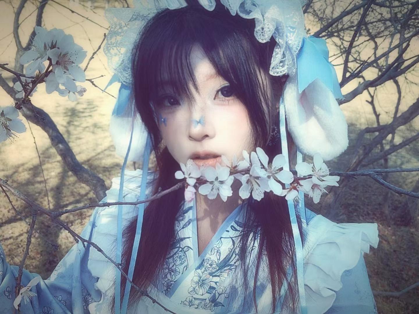 横幅构图中的蓝衣人物与花枝